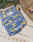 A photo of cloth pocket nappies in a bumble bee print featuring hemp boosters, showcasing an eco-friendly diapering choice with colorful, reusable fabrics