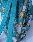Back of teal backpack with cartoon characters pattern on a white background