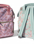 Two floral-patterned backpacks on grass