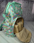 Parents baby changing bag Backpack with rainbow and cloud pattern on a wooden surface