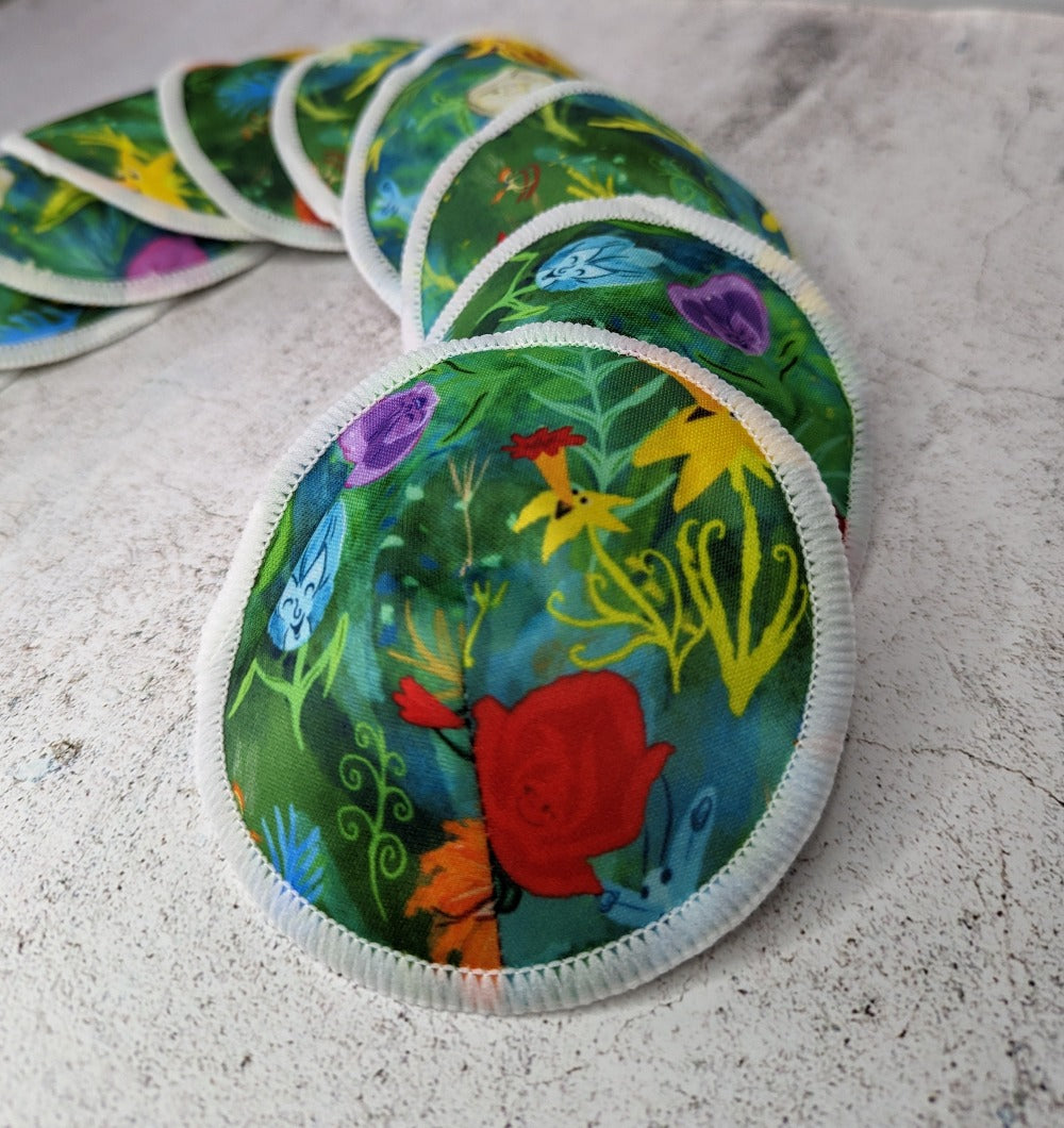 Shaped bamboo reusable breast pads featuring a whimsical Alice in Wonderland print, providing both comfort and sustainability for nursing mothers
