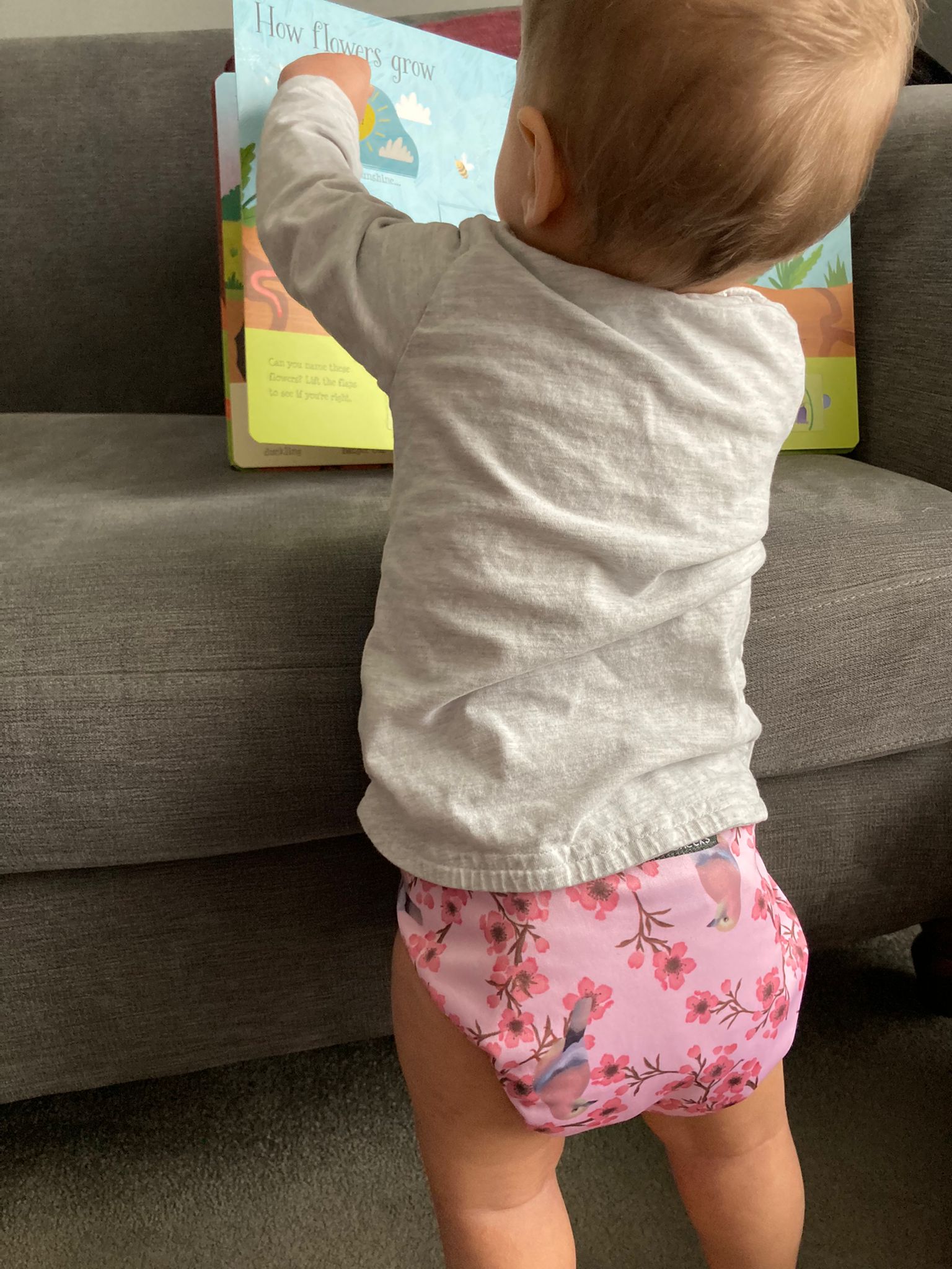 A baby wears a pink cloth nappy