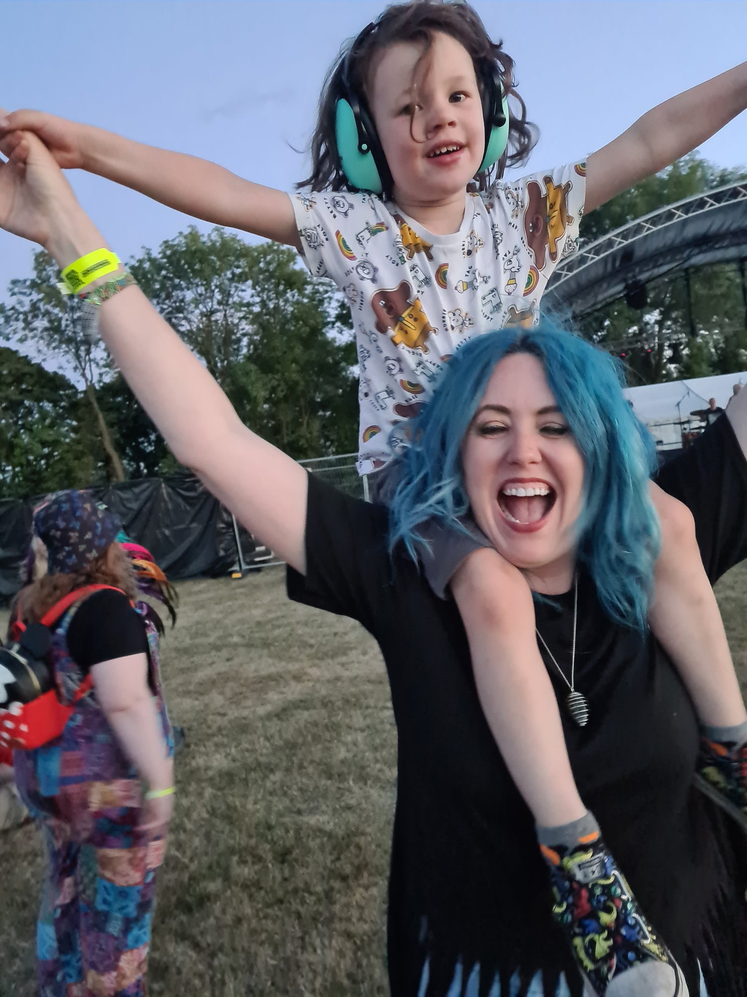 A blue haired Mum and son having fun a festival