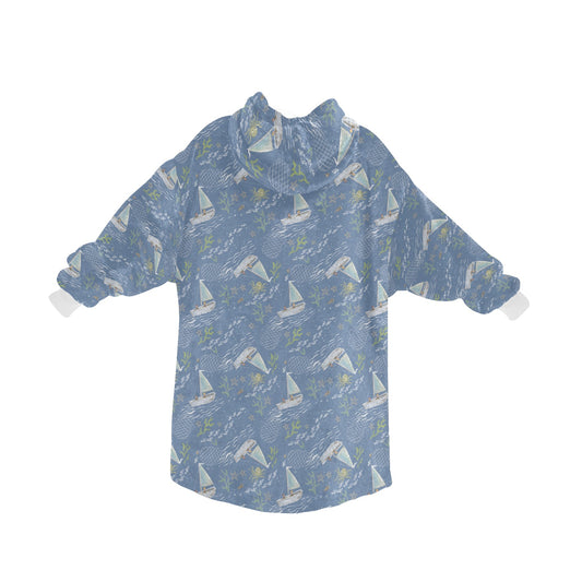 A warm and comfortable fleece hooded blanket in a calming blue boats pattern, similar to the Oodie, perfect for wrapping up and staying snu