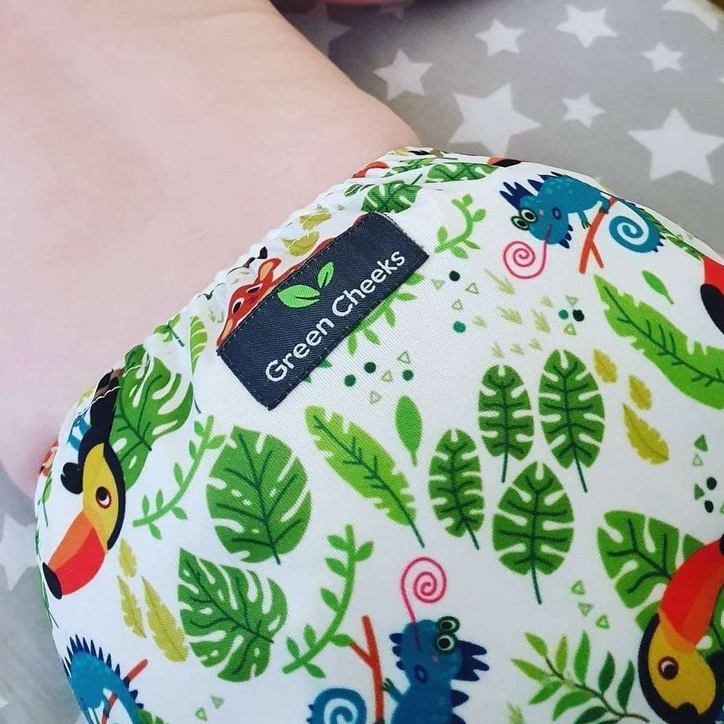 A baby wears a Green Cheeks reusable nappy.