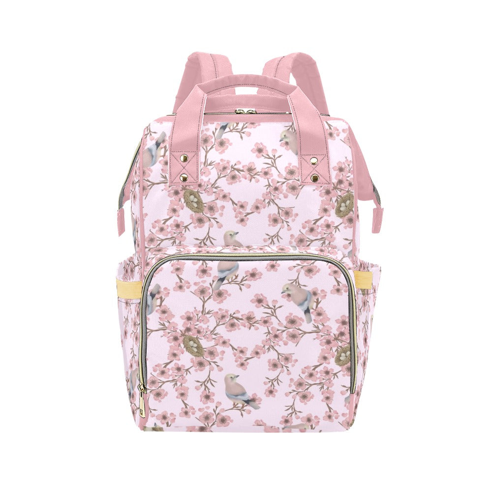 Floral-patterned baby changing nappy backpack with pink straps on a white background, spring inspired cherry blossom
