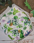 Cloth pocket nappies with hemp boosters in various vibrant colors, providing a sustainable way to keep babies comfortable and dry featuring a cute chameleon