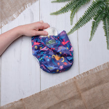 Load image into Gallery viewer, A hand shows how to remove the pads from a washable nappy
