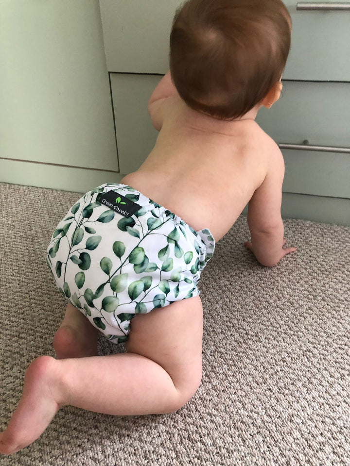 An assortment of cloth nappies, diaper covers, and inserts, highlighting sustainable diapering choices