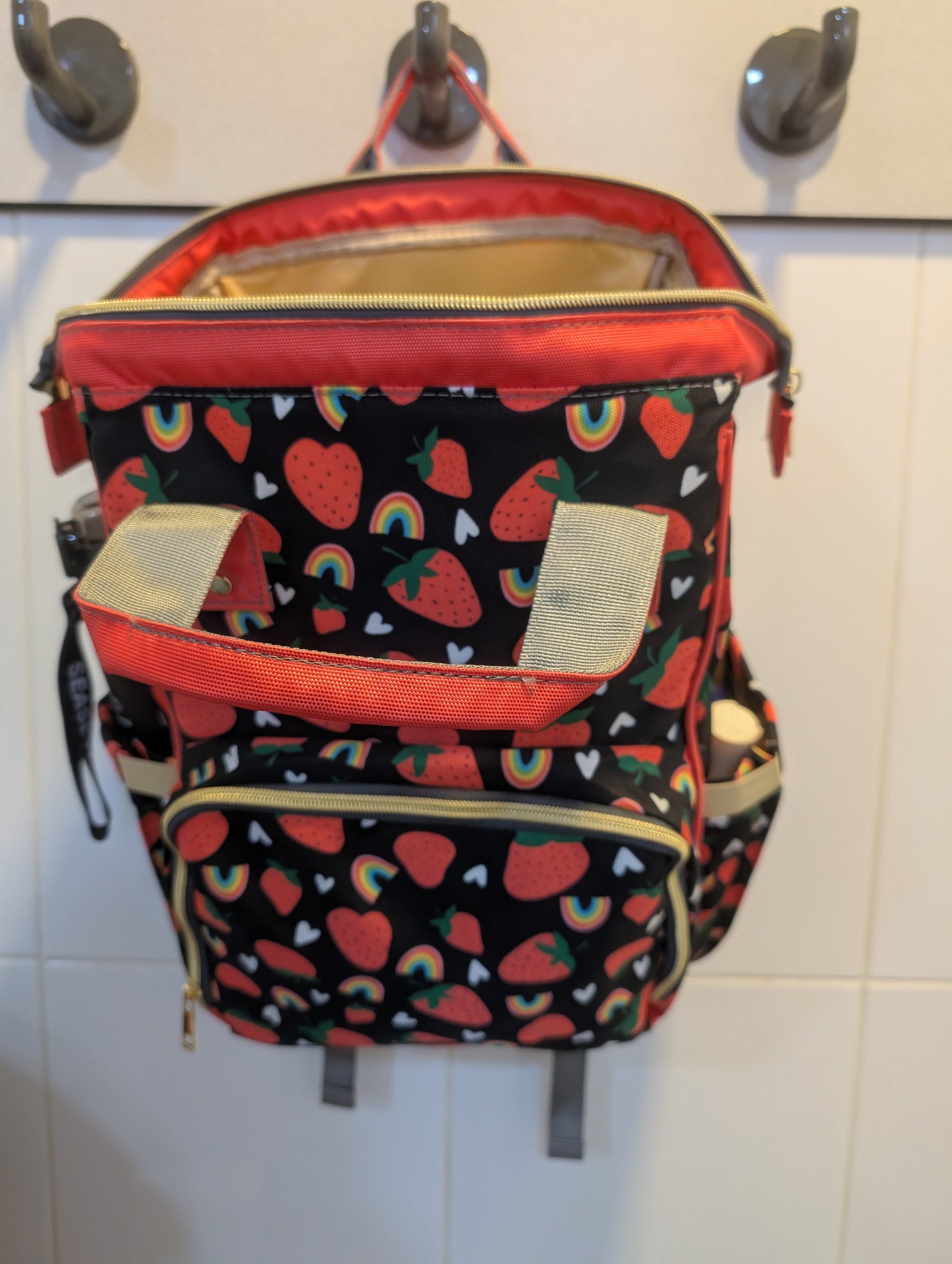Backpack with colorful patterns hanging on a tiled wall