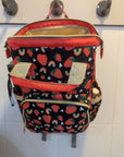 Backpack with colorful patterns hanging on a tiled wall