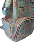 Floral-patterned bag with a gold zipper on a close up of a baby nappy changing bag