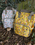 Two patterned bags on the ground with a natural background, Green Cheeks baby changing bags with hedgehog.