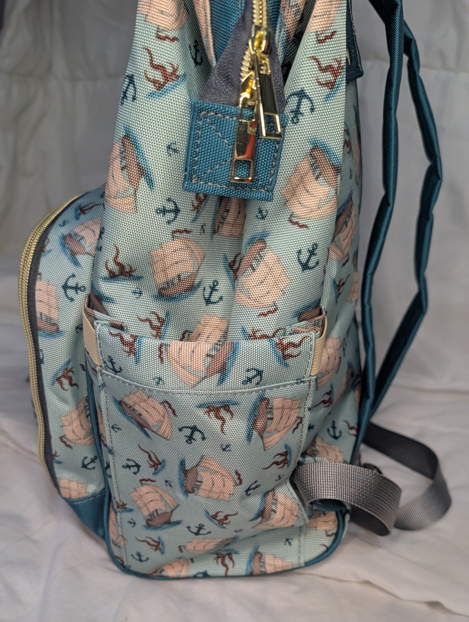 Backpack with nautical pattern on a light background showing side pocket
