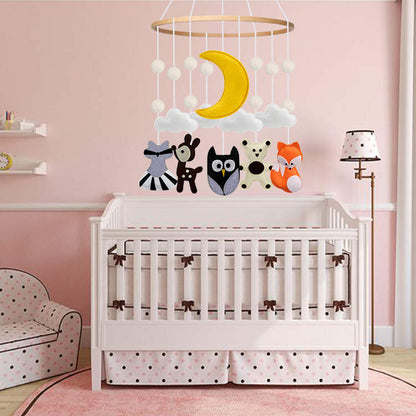 Woodland-themed baby cot mobile hanging above a crib in a cozy forest-inspired nursery.