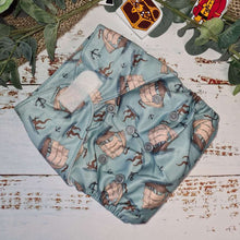 Load image into Gallery viewer, A snapshot of cloth diapers with hemp boosters, an environmentally conscious diapering solution, in a blue pirate print
