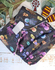 An overhead view of cloth pocket nappies and hemp boosters, an excellent choice for eco-conscious parents in a black and purple under water print. 