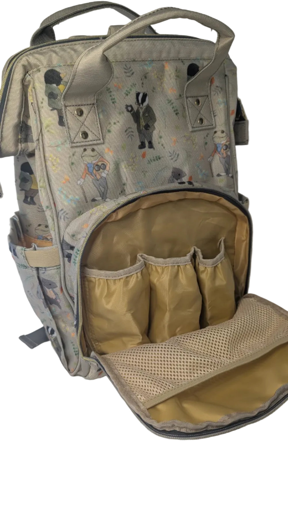 A beige and gray patterned diaper backpack with an open front pocket showing a gold interior organizer, photographed on a white fabric surface.