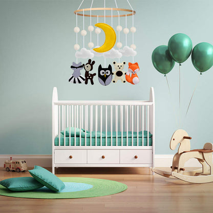 Woodland baby cot mobile with fox, owl, deer, bear, clouds, and crescent moon hanging from a wooden ring in muted tones, perfect for gender-neutral nurseries.
