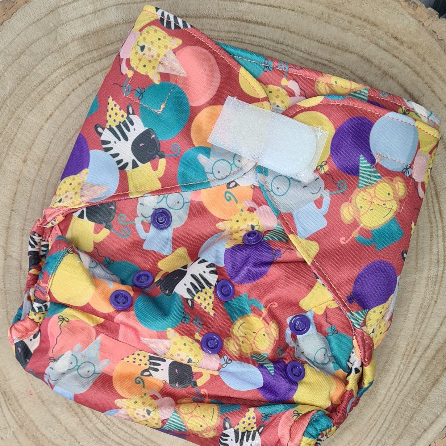 A cloth nappy wrap in a first birthday print