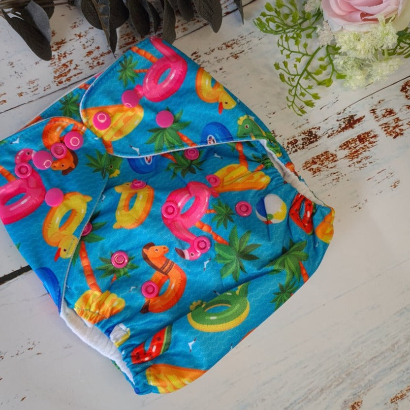 Cloth pocket nappies with hemp boosters in various vibrant colors, providing a sustainable way to keep babies comfortable and dry in blue and pink, unisex design.
