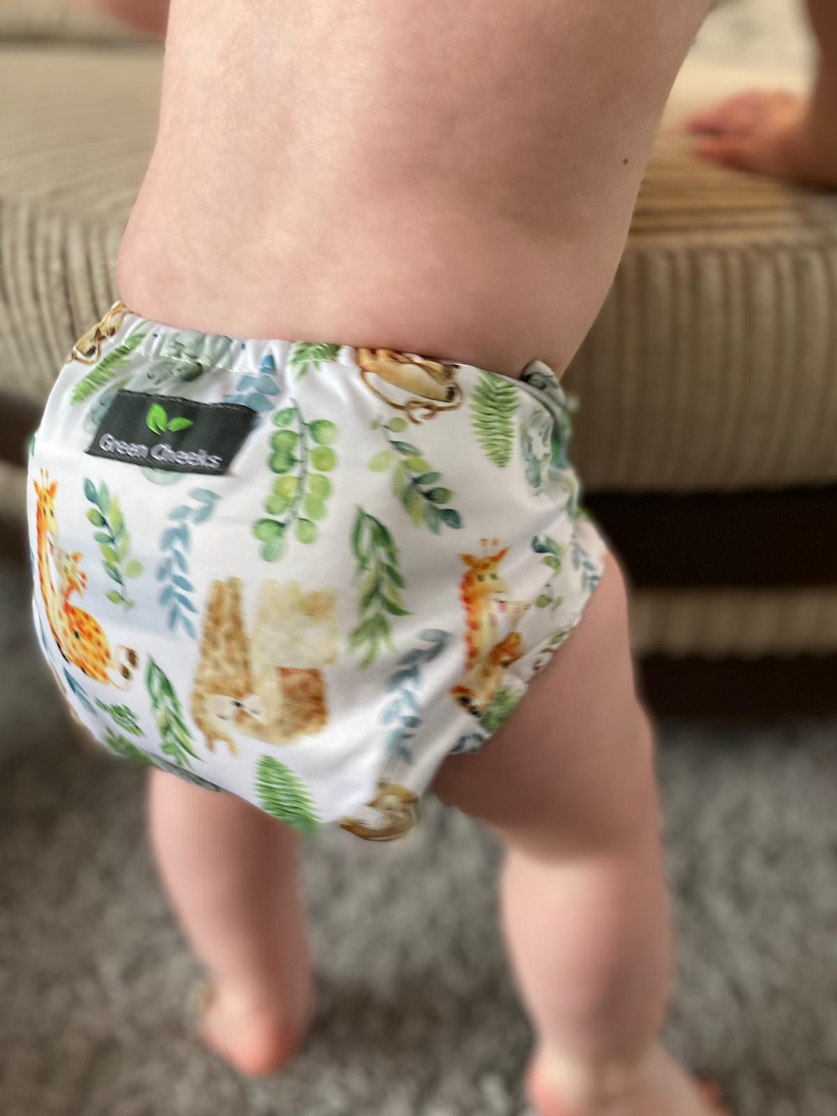 Green Cheeks Two Part Nappy System Sleepy Head is worn by a standing baby