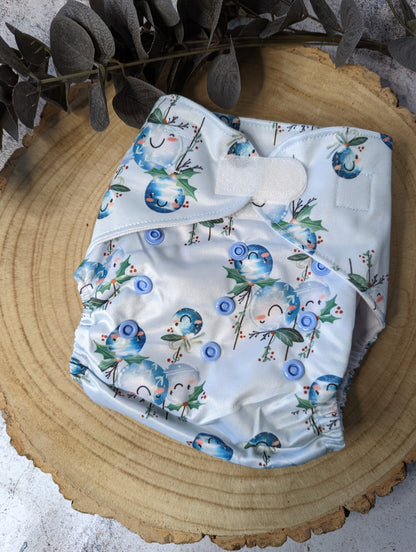 Christmas-themed cloth pocket nappies with festive patterns, featuring velcro fastening for easy and secure diapering